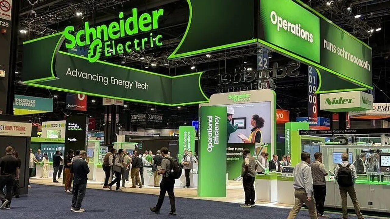 Schneider Electric exhibition booth with visitors at a trade show.