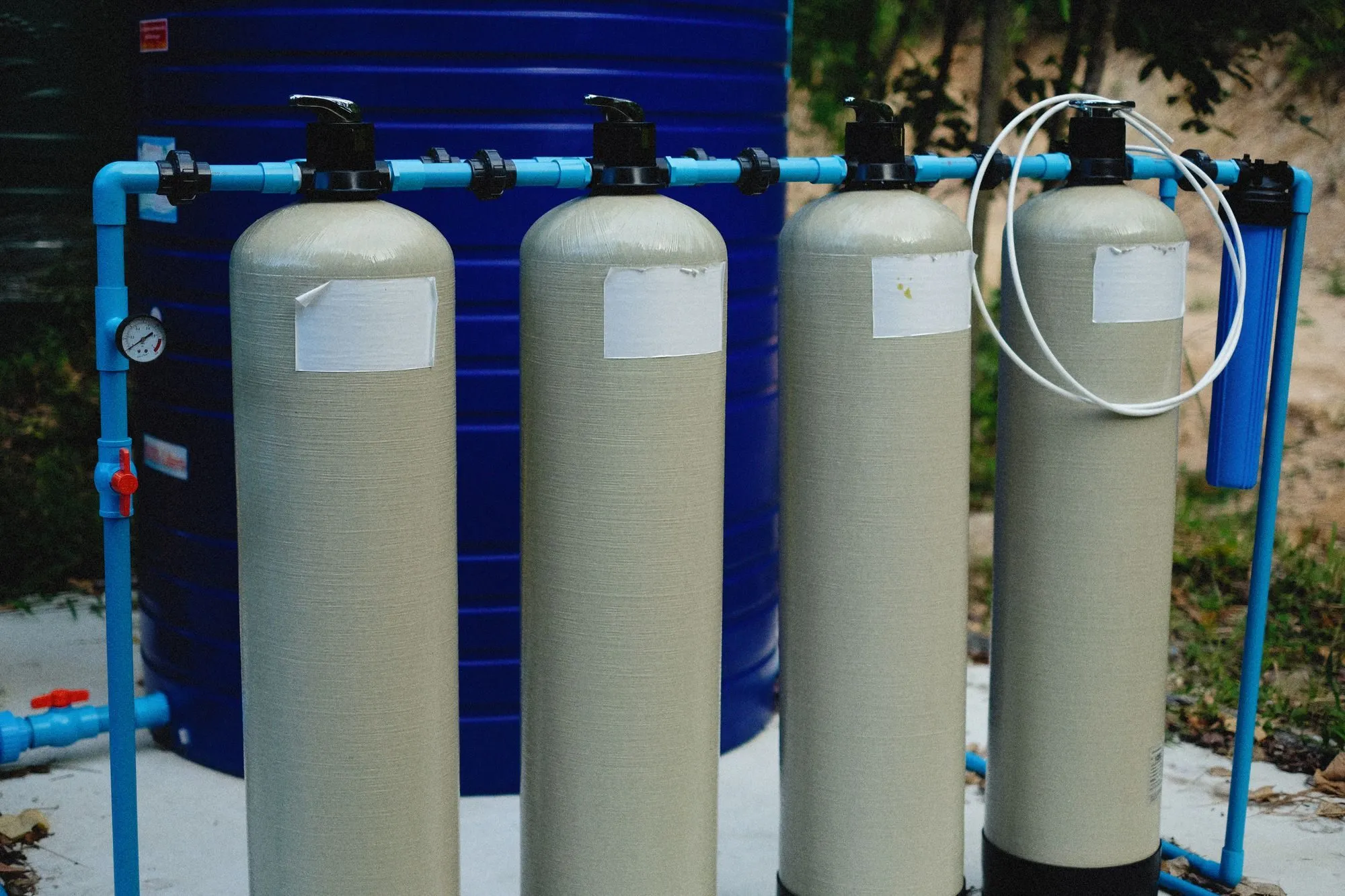 Four filter vessels with blue pipework at a water treatment plant